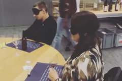 Personen mit Augenbinden am Tisch.
